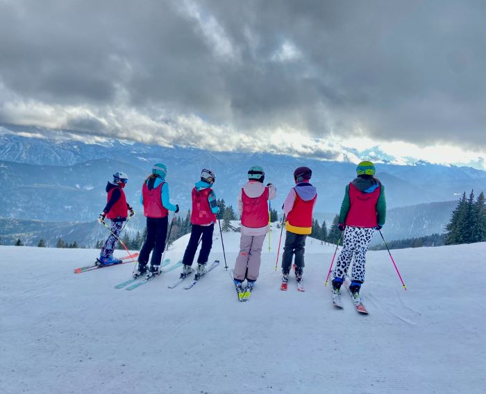 Kinder auf Skiern vor einer schönen Bergaussicht